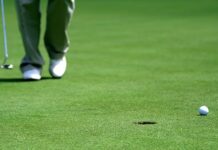 What Causes The ‘yips’ In Golf Putting? A golfer with a club approaching a putt